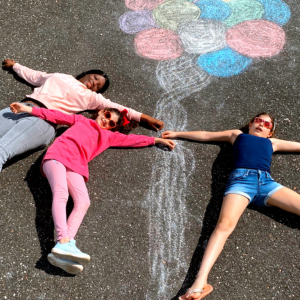 au pair with kids laying on driveway