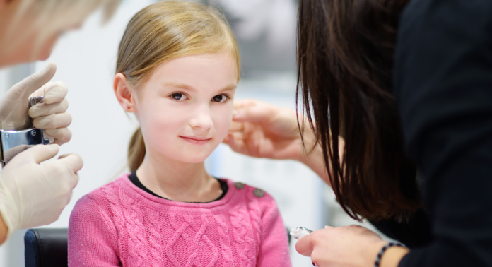 girl getting ears pierced