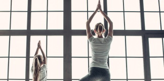 mom doing yoga pose with daughter