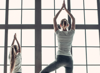 mom doing yoga pose with daughter