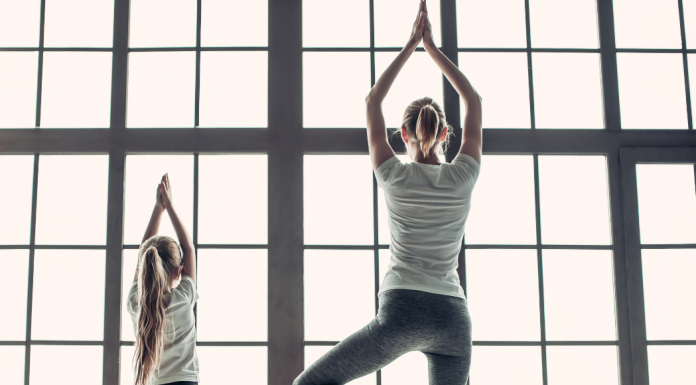 mom doing yoga pose with daughter