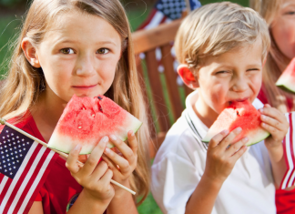 kids eating watermelon and holding American flags