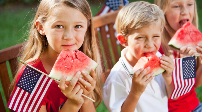 kids eating watermelon and holding American flags