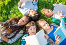 kids reading books in grass