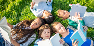 kids reading books in grass