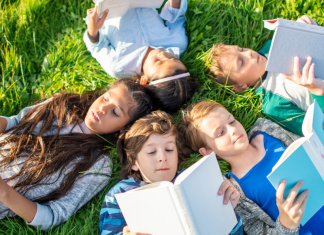 kids reading books in grass