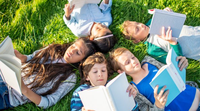 kids reading books in grass