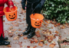 kids trick or treating carrying pumpkin buckets