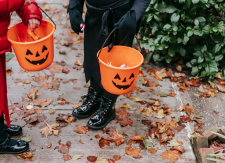 kids trick or treating carrying pumpkin buckets