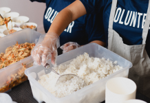 kids with shirts that says volunteer, sorting food