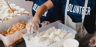 kids with shirts that says volunteer, sorting food