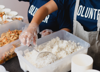 kids with shirts that says volunteer, sorting food