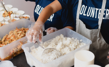 kids with shirts that says volunteer, sorting food