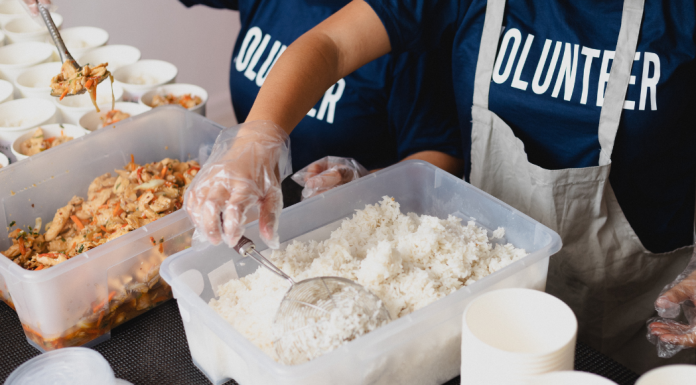 kids with shirts that says volunteer, sorting food