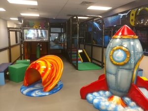 Soft, space-themed play equipment and climbing area for toddlers at Kookalooz indoor play space in Denver. 